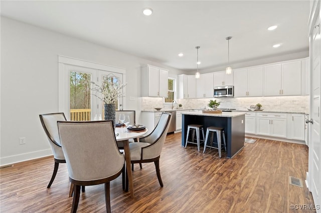 dining area with recessed lighting, dark wood-style flooring, and a healthy amount of sunlight
