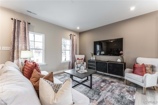 living area featuring visible vents, recessed lighting, baseboards, and wood finished floors