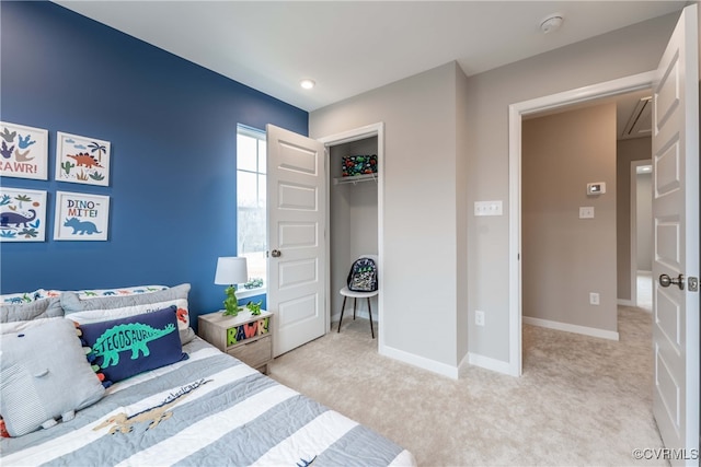 bedroom with baseboards, a closet, and light colored carpet