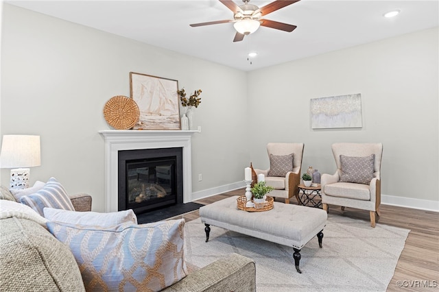 living room featuring a ceiling fan, baseboards, recessed lighting, and wood finished floors