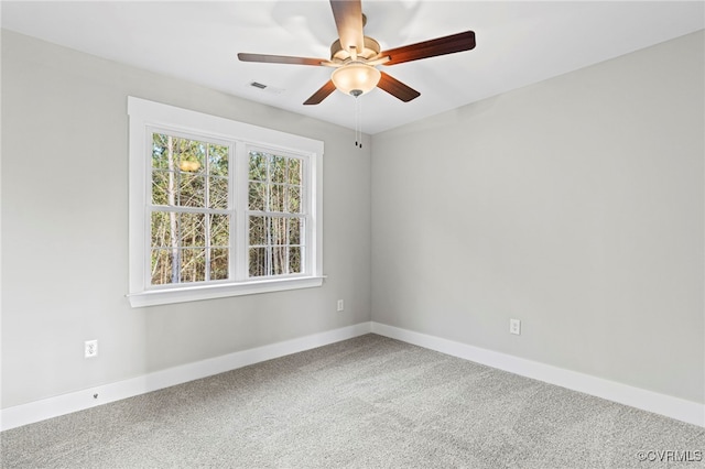spare room featuring baseboards, carpet, a ceiling fan, and visible vents