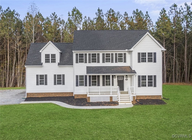 view of front of house with a porch, a shingled roof, and a front yard