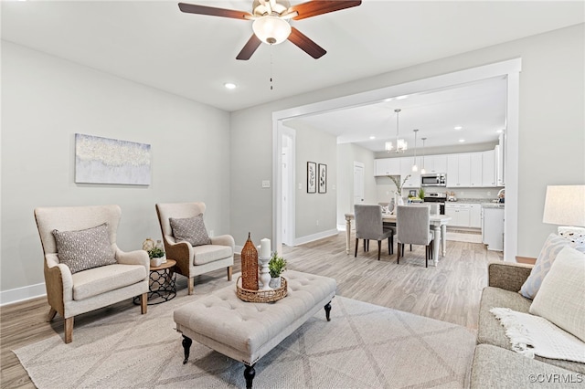 living room with recessed lighting, baseboards, and light wood-type flooring