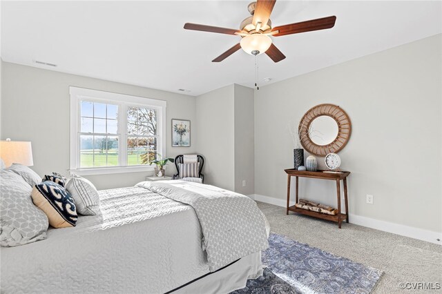 carpeted bedroom featuring baseboards, ceiling fan, and visible vents