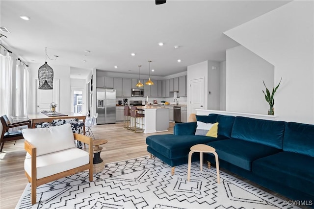 living area featuring recessed lighting, light wood-type flooring, and visible vents