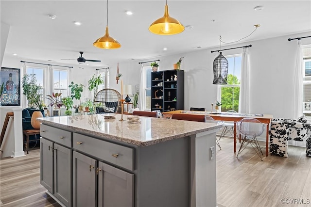 kitchen with plenty of natural light, light wood-style flooring, gray cabinets, and open floor plan