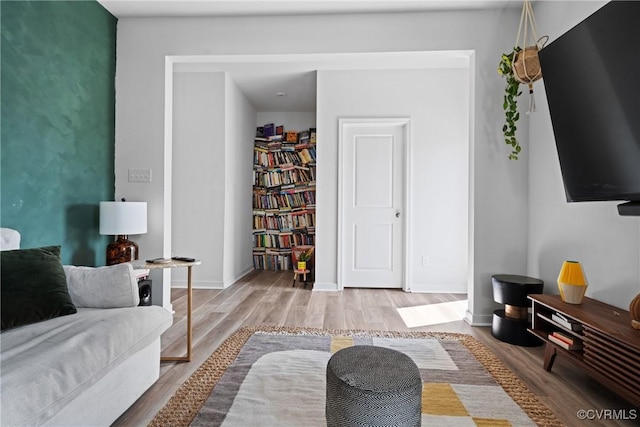 living area with baseboards and wood finished floors