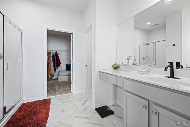 full bath featuring visible vents, marble finish floor, baseboards, a walk in closet, and a shower stall