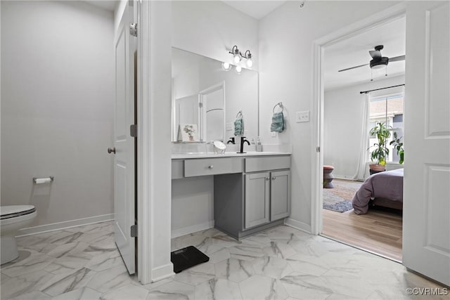 bathroom with toilet, ceiling fan, marble finish floor, and vanity