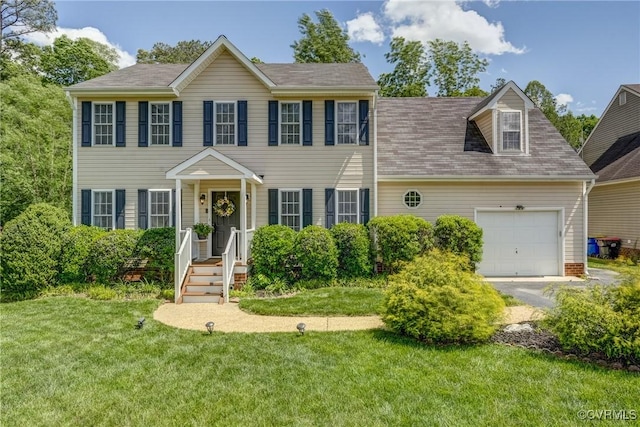 colonial-style house featuring a front yard, roof with shingles, an attached garage, and driveway
