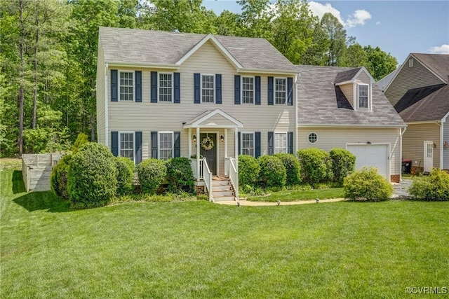 colonial house featuring an attached garage and a front lawn