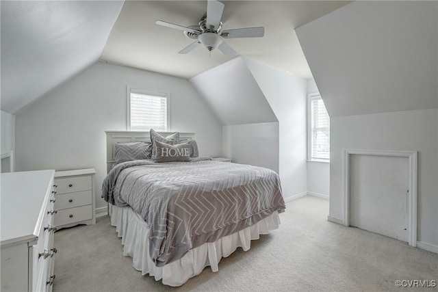 bedroom featuring vaulted ceiling, light carpet, baseboards, and a ceiling fan