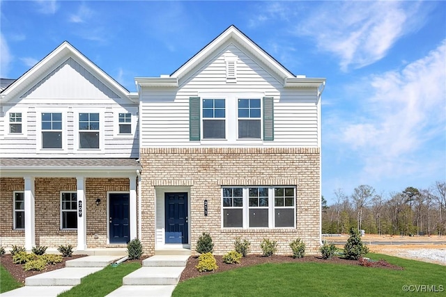 view of front of home with a front yard and brick siding
