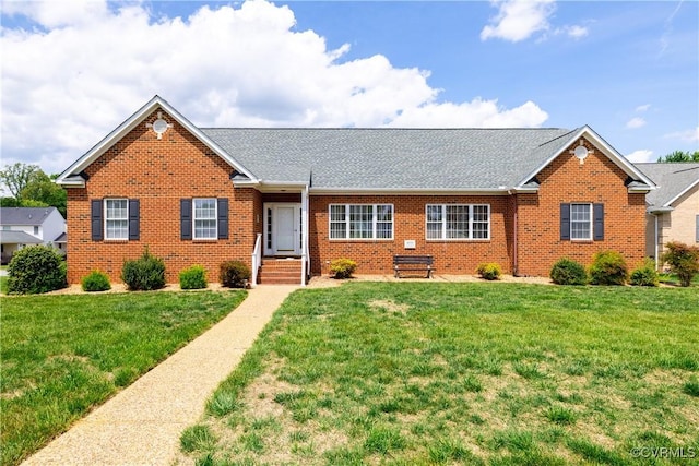 single story home with a shingled roof, a front lawn, and brick siding