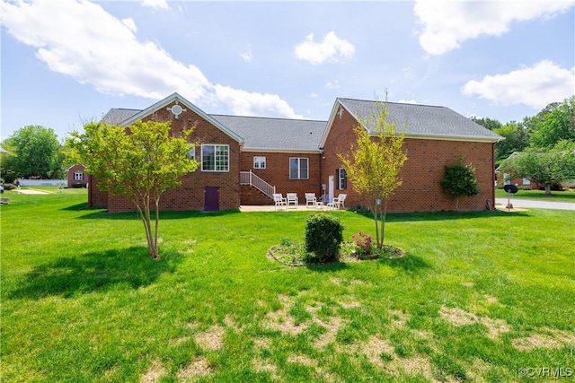 exterior space featuring a yard, brick siding, and a patio area