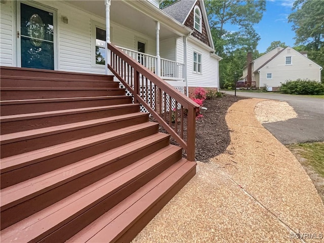 exterior space with roof with shingles and covered porch