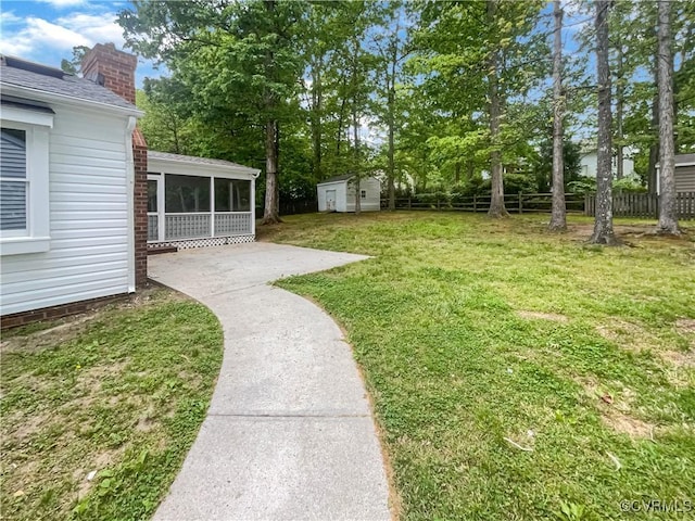 view of yard with fence, an outdoor structure, and a sunroom