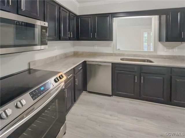 kitchen featuring light countertops, stainless steel appliances, ornamental molding, and dark cabinets
