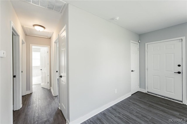interior space with visible vents, attic access, baseboards, and dark wood-type flooring