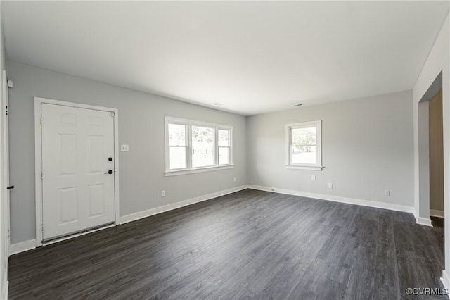 interior space with baseboards and dark wood-style flooring