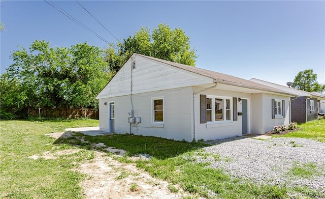 view of side of property with fence and a lawn