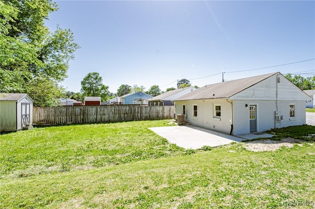 view of yard featuring a fenced backyard, a patio, an outbuilding, and a shed
