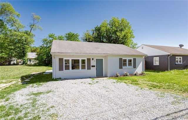 view of front of house featuring stucco siding and a front lawn