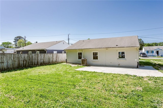 rear view of property with fence, a patio, stucco siding, and a lawn