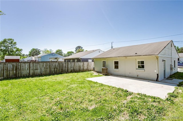 back of house with a fenced backyard, a patio, and a lawn