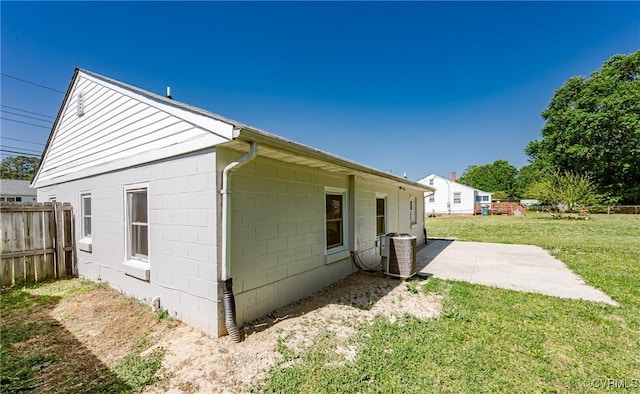 view of side of home with fence, a yard, cooling unit, and a patio area
