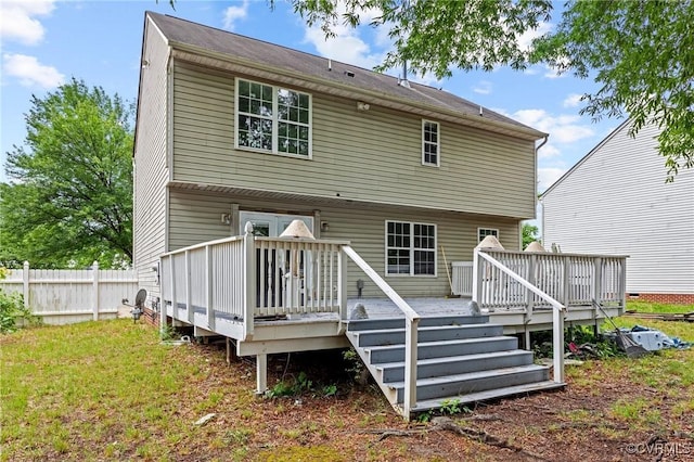 rear view of house with a deck and fence
