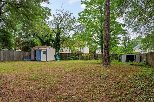 fenced backyard featuring a storage shed and an outbuilding
