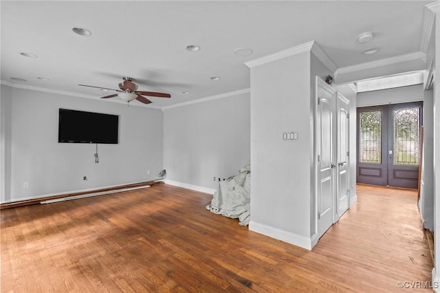 unfurnished room featuring a ceiling fan, light wood finished floors, crown molding, baseboards, and a smoke detector