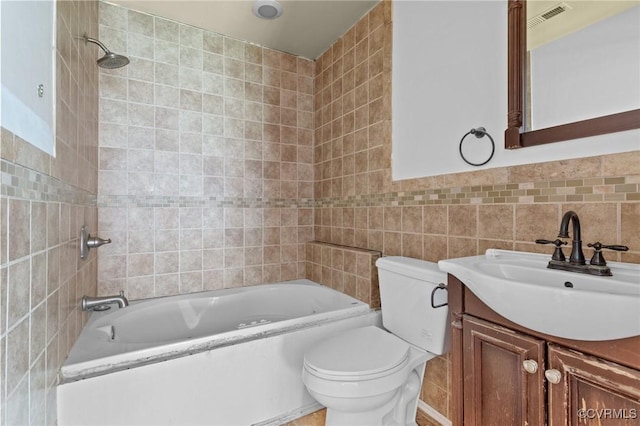 full bath with tile walls, toilet, vanity, and shower / washtub combination