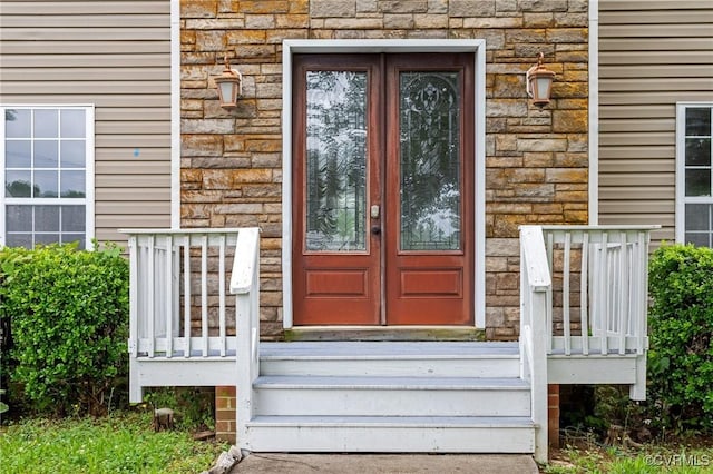 property entrance with stone siding and french doors