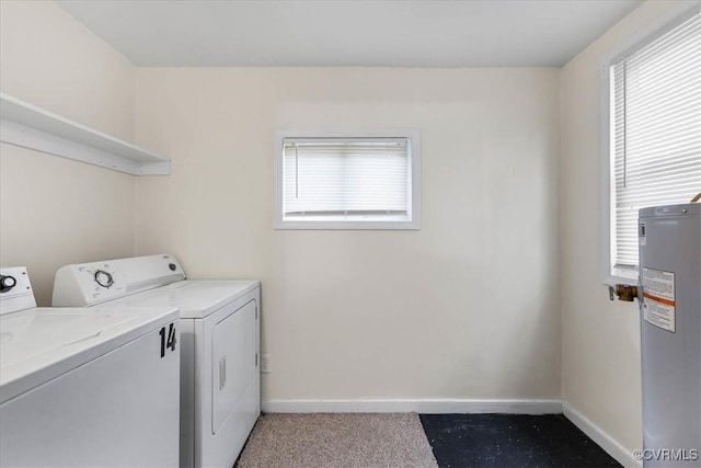 washroom featuring laundry area, baseboards, washer and dryer, and a wealth of natural light