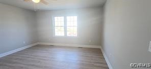 unfurnished room with baseboards, ceiling fan, and wood finished floors