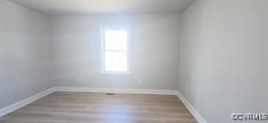 empty room featuring baseboards and wood finished floors
