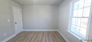 unfurnished room with baseboards and wood finished floors