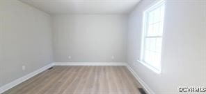 empty room with baseboards and wood finished floors