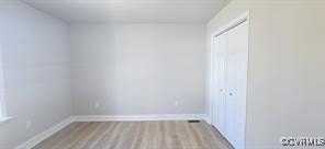 interior space with a closet, baseboards, and wood finished floors
