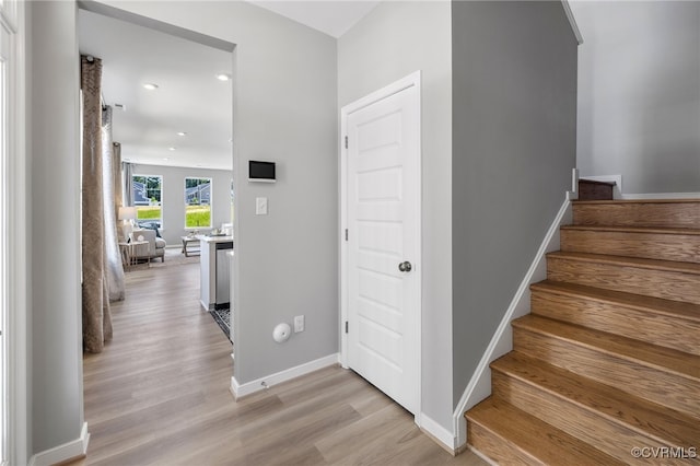 stairs with recessed lighting, baseboards, and wood finished floors