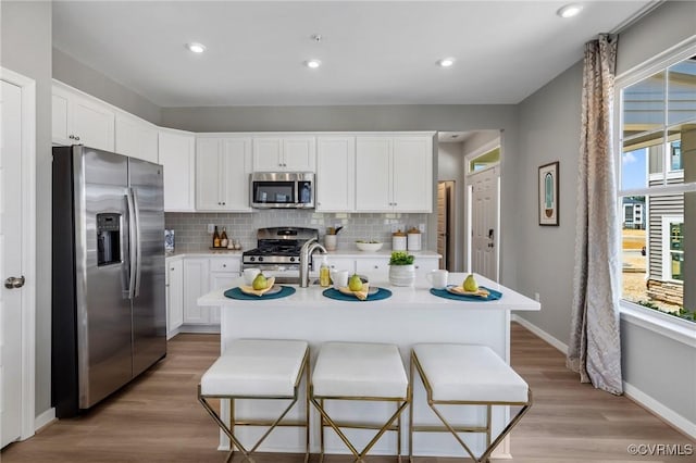 kitchen with light countertops, tasteful backsplash, stainless steel appliances, and plenty of natural light