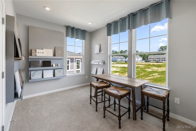 carpeted dining area featuring baseboards