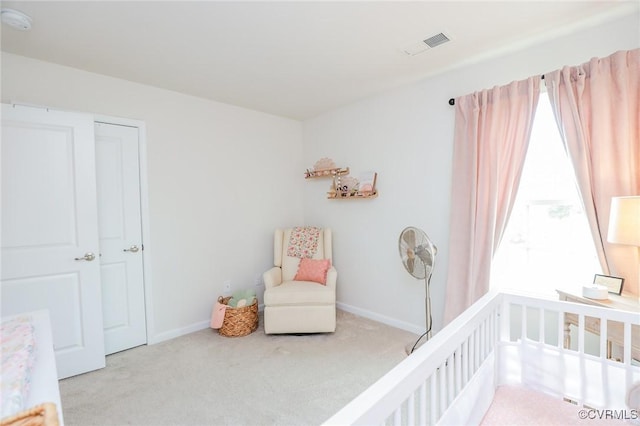 bedroom with carpet floors, a nursery area, baseboards, and visible vents