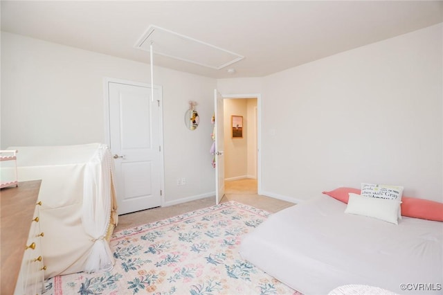 bedroom with baseboards, attic access, and light colored carpet