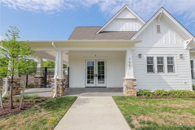 view of front of property featuring french doors, fence, board and batten siding, and a front yard