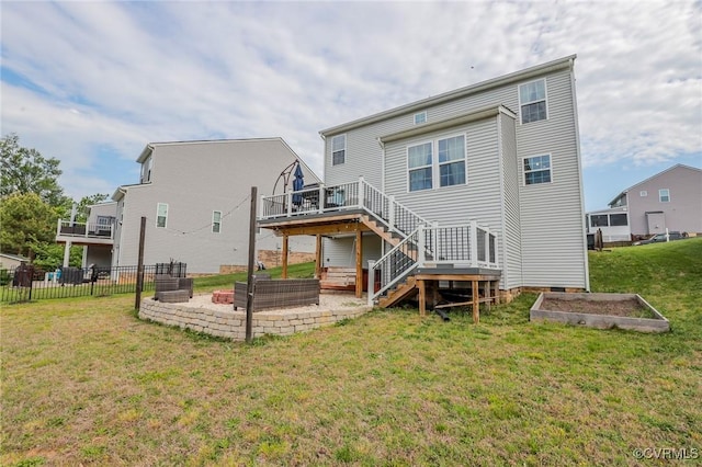 rear view of house with a wooden deck, a vegetable garden, stairway, fence, and a yard