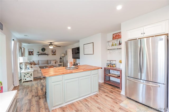 kitchen with ceiling fan, light wood-type flooring, white cabinetry, freestanding refrigerator, and butcher block countertops