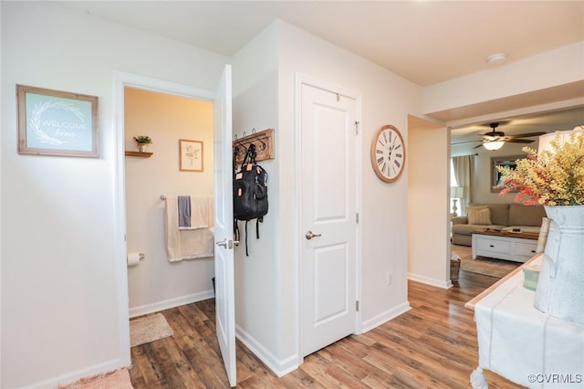 hall with baseboards and light wood-style flooring